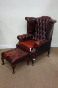 Wingback armchair upholstered in buttoned red leather and matching footstool Condition