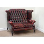 Wingback two seat sofa upholstered in buttoned red leather,