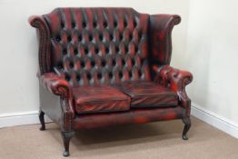 Wingback two seat sofa upholstered in buttoned red leather,
