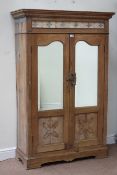 Indian teak cupboard enclosed by carved panelled and bevel mirror glazed doors, with tiled frieze,