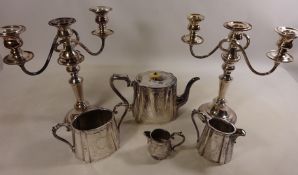 Three piece silver plated tea set and a pair of silver plated candelabra's and a small jug