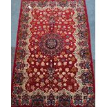 Persian Keshan rug, stylized central rosette medallion over red ground,