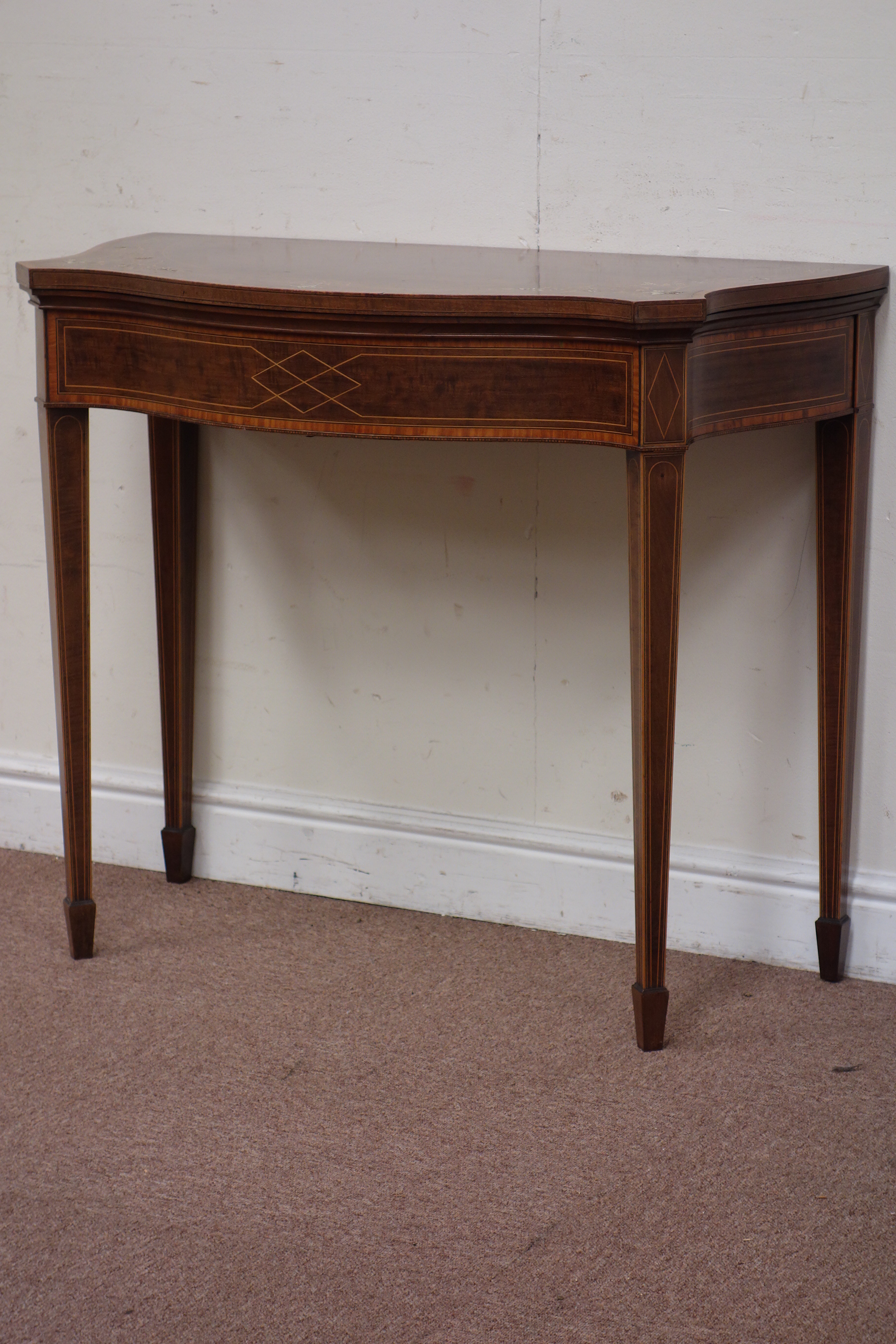 Edwardian inlaid mahogany serpentine fold over top card table, tooled baise lined,