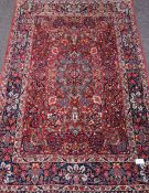 Persian Qum rug, red ground, overall floral design, boteh and flowers and vase motifs,