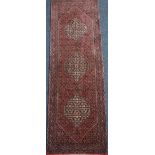 Persian Bidjar rug, triple medallion within elongated lozenges, over red ground,