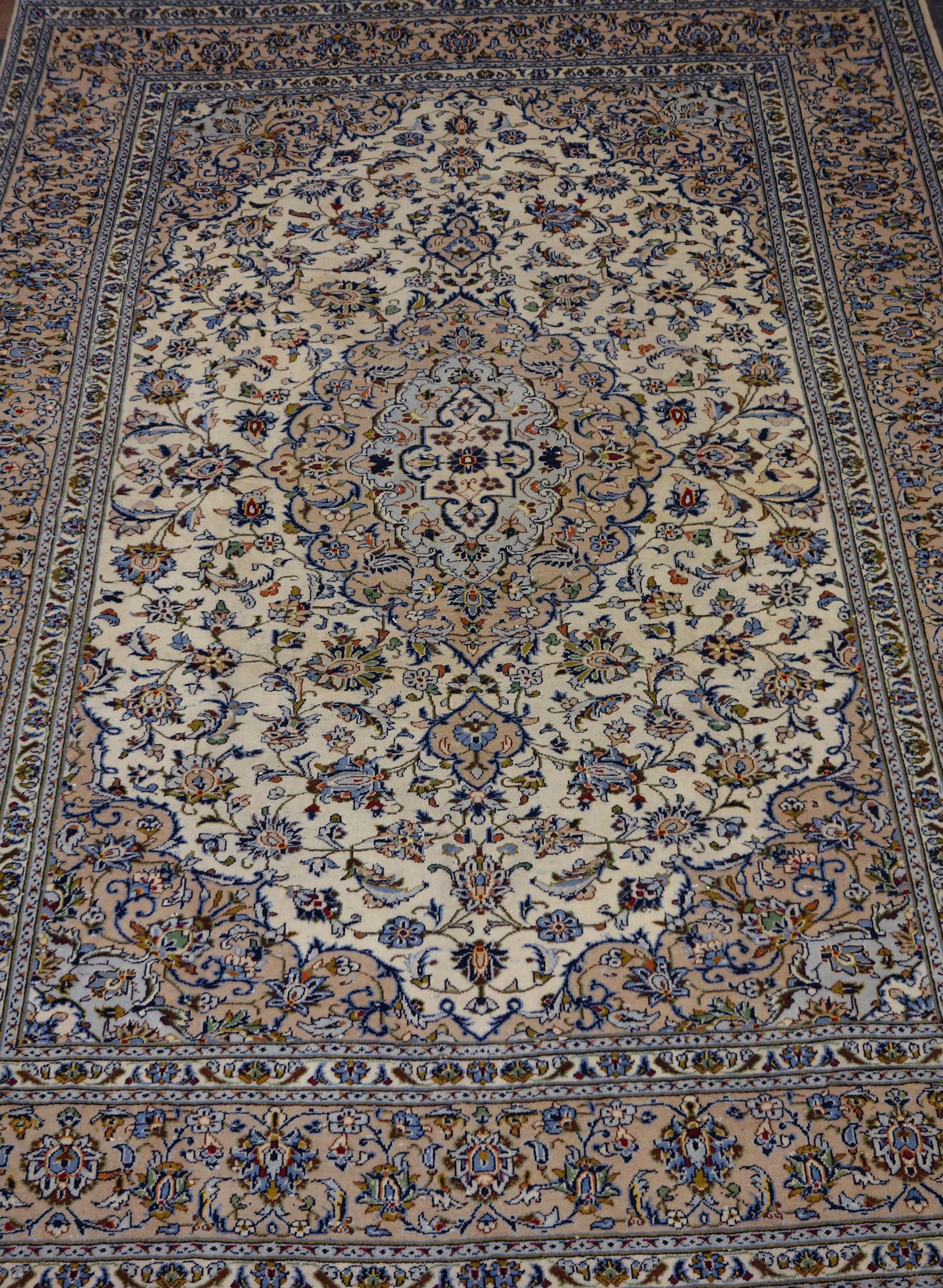 Persian Kashan rug, large central medallion within beige all over floral decorated field,