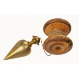 A 2 1/2" steel tipped brass plumb bob with pretty knurling to finial on boxwood reel F