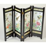 A Chinese black lacquer, four fold table screen set with bird and flower decorated tiles,