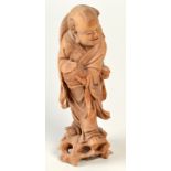 A Chinese wood figure of a standing, smiling Daoist Immortal holding a basket, height 32cm.