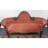 A good Victorian carved walnut sofa with an arched, buttoned back and serpentine front.