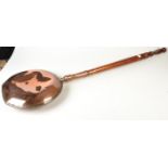 A Victorian copper hot water warming pan with a turned handle.
