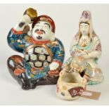 A Japanese Kutani seated, coloured enamelled figure of Daikoku holding his magic mallet,
