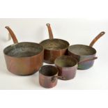 Five graduated copper saucepans each with iron handle.