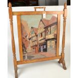 A 1930's oak fire screen set with a woolwork of a half timbered building.