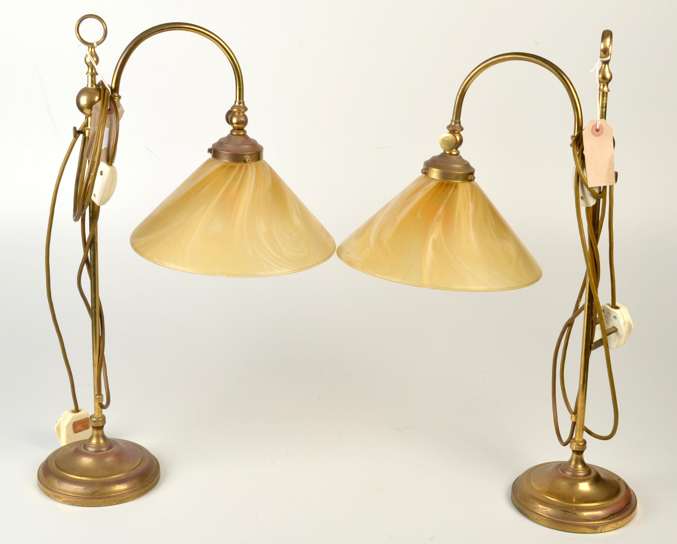 A pair of brass adjustable desk lamps.