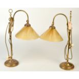 A pair of brass adjustable desk lamps.