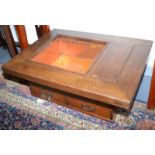 A Japanese wooden hibachi with metal liner, flanked by a lidded section above two drawers.