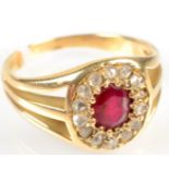 A high purity gold ring with an oval ruby surrounded by diamonds and with pierced shoulders.