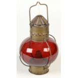 A ship's brass and red glass lamp, height 30cm.