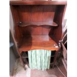 A narrow Regency style bookcase with a single open shelf above a curtained, adjustable shelf.