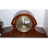 A mantle clock with Westminster chime in an arched, inlaid mahogany case.