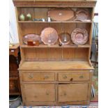 A 19th century pine dresser with open shelves, the base with two drawers over two boarded doors,