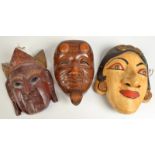 Three oriental carved wood masks.