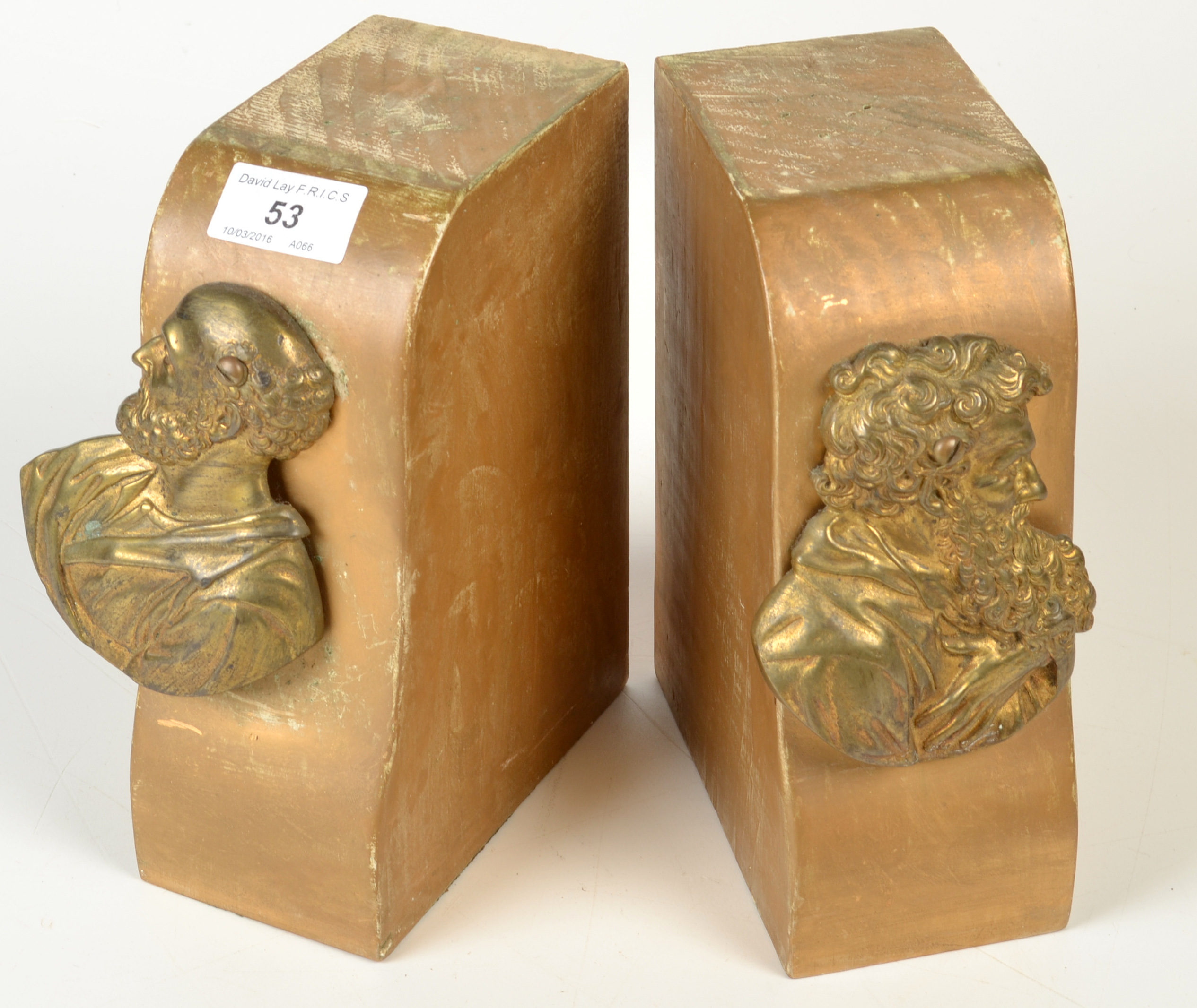 A pair of giltwood book ends, each mounted with a brass plaque of a classical figure.