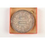 A silver coloured metal Cookney prize medal by Royal Naval School, New Cross, diameter 1.75 inches.