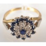 An 18ct. gold ring set a diamond and sapphire cluster.