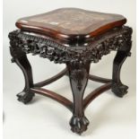 A Chinese carved hardwood jardiniere stand with marble inset top above a carved,