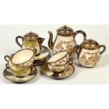 A Japanese Satsuma tea service, comprising a teapot, sugar bowl, milk jug and five cups and saucers,