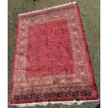 A Bokhara style carpet, machine made, the red ground decorated with multiple rows of guls,