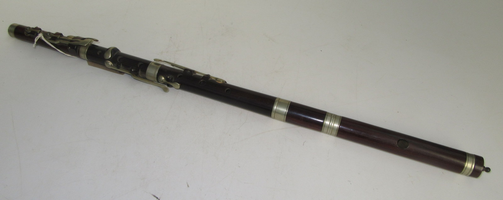 A rosewood flute with nickel keys and rings, length including finial 68.5cm.