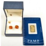 A 24ct. gold ingot, 2.5g, together with a pair of gold mounted amber coloured earrings.