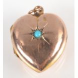 A gold heart shaped locket set with a turquoise.