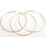 A set of three 18ct. gold bangles 18.8g. Condition report: Very slightly mis-shaped.