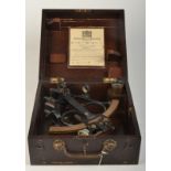 A Sestrel sextant with a brass guage and brown bakelite handle, original hardwood box, with lens.