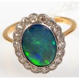 An 18ct. gold opal and diamond oval cluster ring.