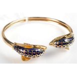 A 14ct. gold sprung bracelet, with a pair of blue enamelled dolphin terminals 16.4g.