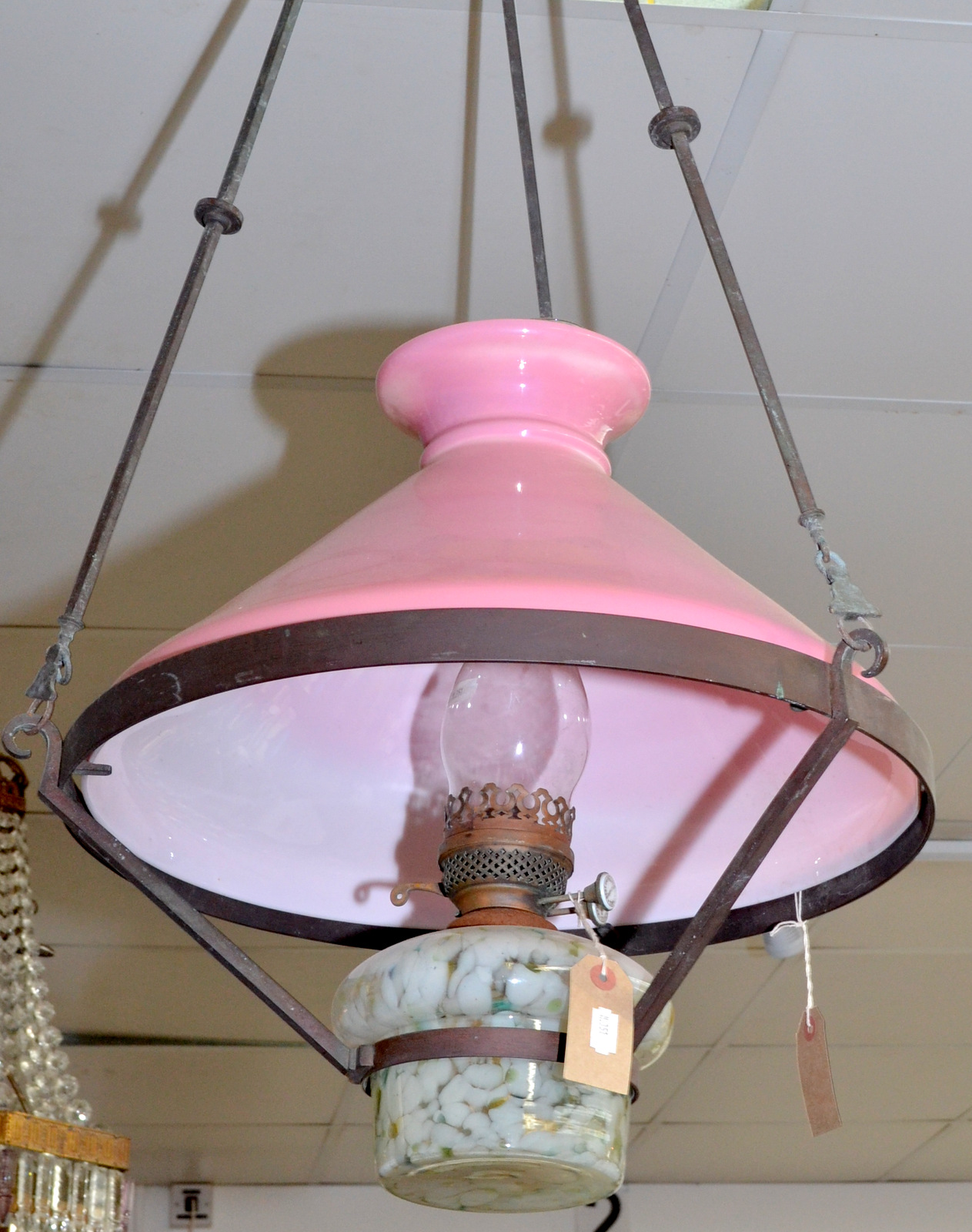 A Victorian pendant brass oil lamp with a marbled glass font and pink shade.