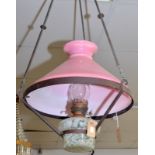 A Victorian pendant brass oil lamp with a marbled glass font and pink shade.