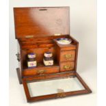 A smokers oak Edwardian stationery cabinet with drawers and compartments,