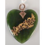 A New Zealand green stone gold mounted heart shape pendant, inscribed 'Kia Ora' in gold.