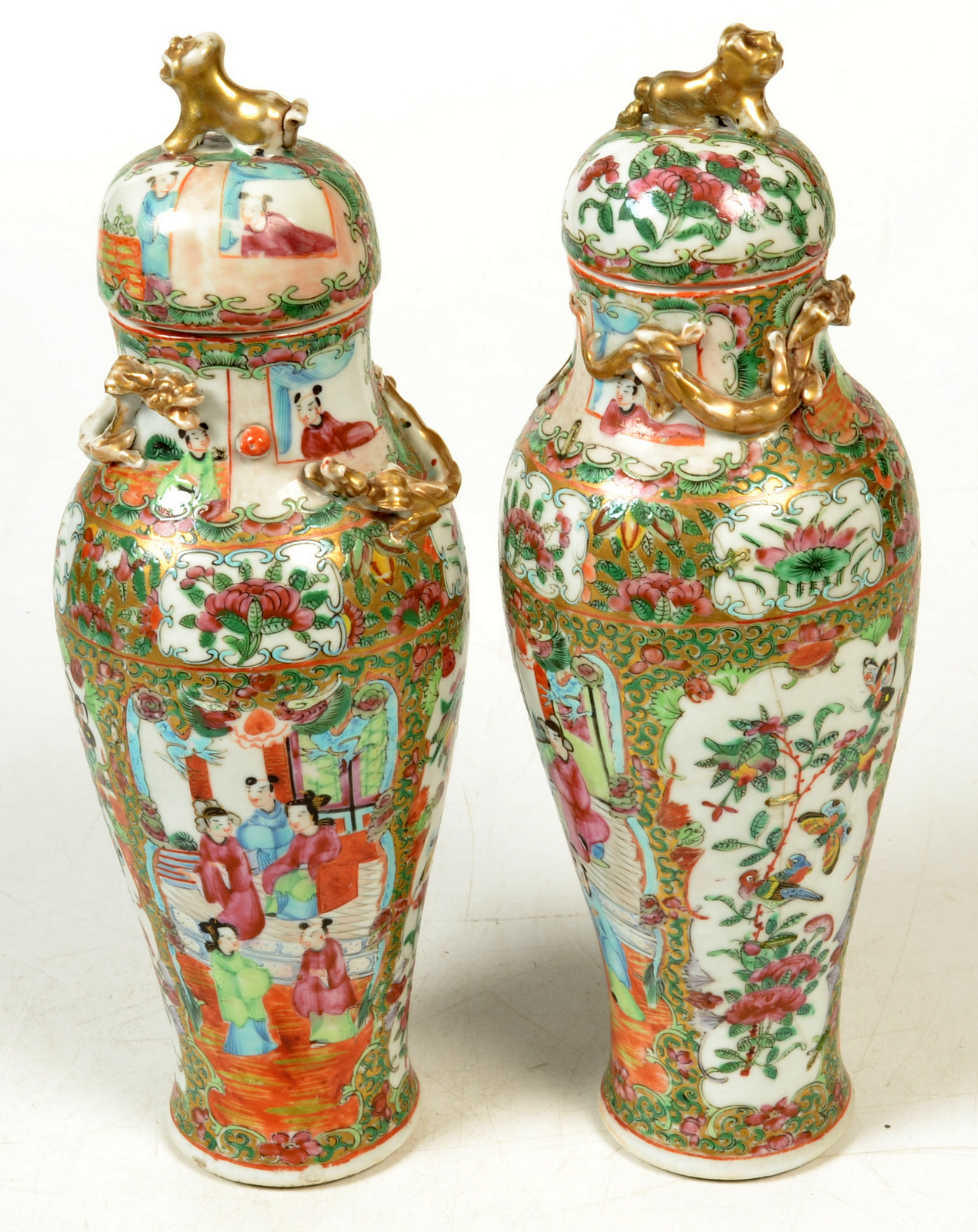 A pair of 19th century Cantonese vases with covers, decorated with interior scenes, flowers,