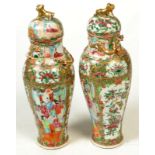 A pair of 19th century Cantonese vases with covers, decorated with interior scenes, flowers,
