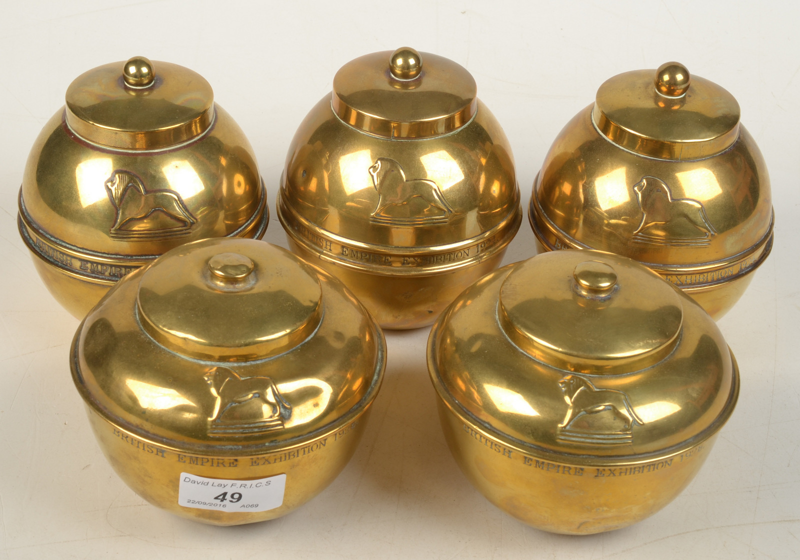 Three Liptons British Empire Exhibition 1924 brass tea caddies and two similar 1925 caddies.