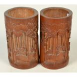 A pair of Chinese bamboo brush pots, carved with figures in a bamboo grove, height 17cm,