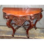 A carved mahogany console table.