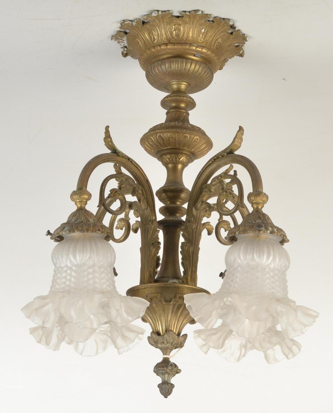 A cast brass four branch electrolier with glass shades, height 47cm.